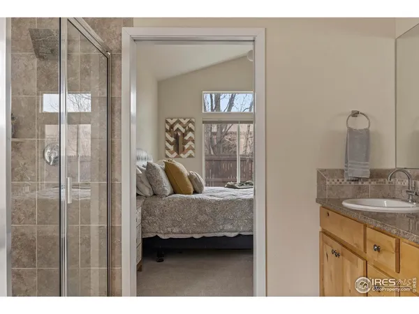 a en suite bathroom with a granite countertop sink and a mirror