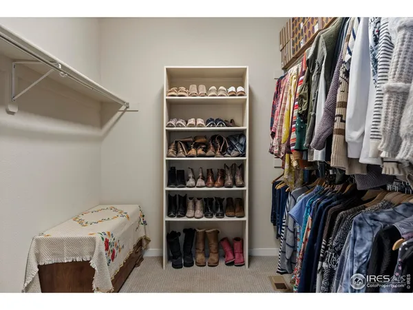 a view of walk in closet with clothes and shoes