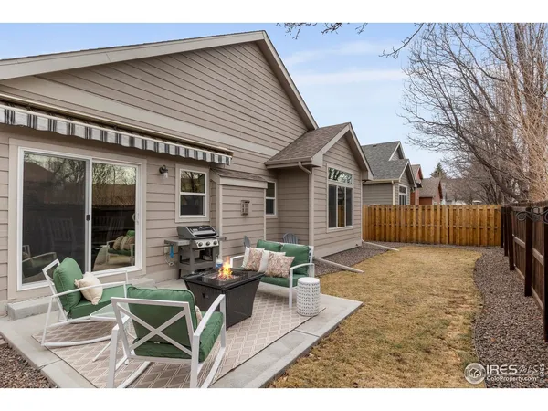 a view of a house with backyard and sitting area