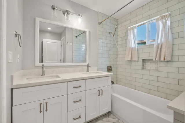 a bathroom with a tub sink and mirror