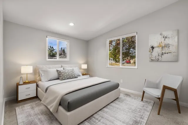 a bedroom with a bed and a painting on the wall