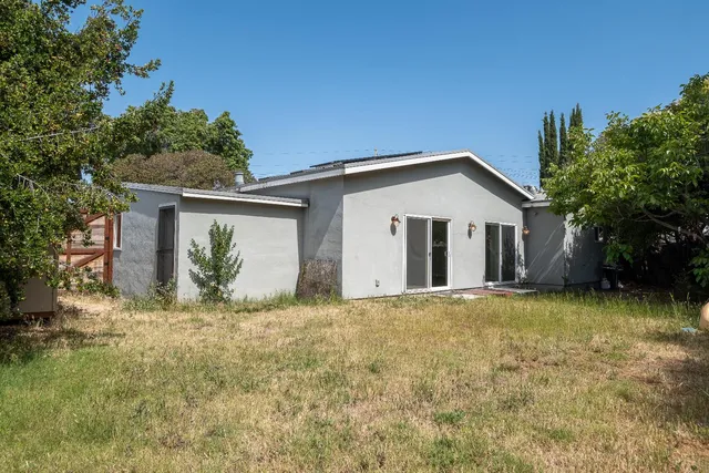 a front view of house with yard and trees in the background