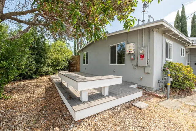 a white house that has tree in front of it