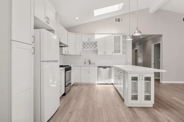 a kitchen with white cabinets and stainless steel appliances