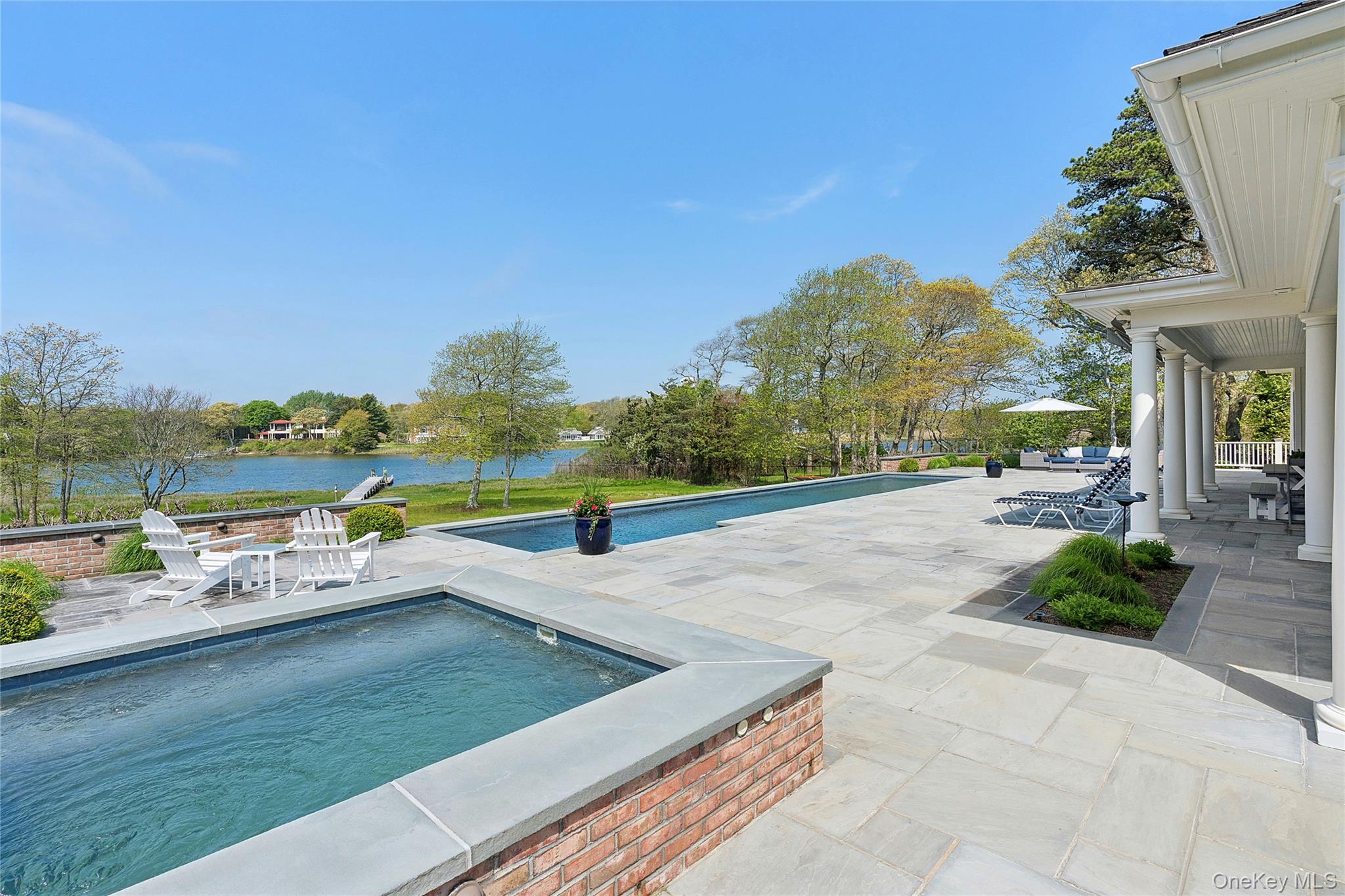 43 Old Main Road Quogue, NY 11959 - Photo 25 of 28 a view of a swimming pool with an outdoor seating and a garden