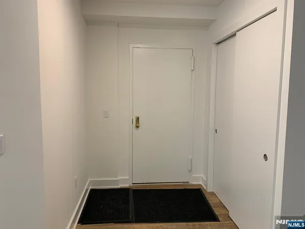 a view of a closet area with hardwood floor