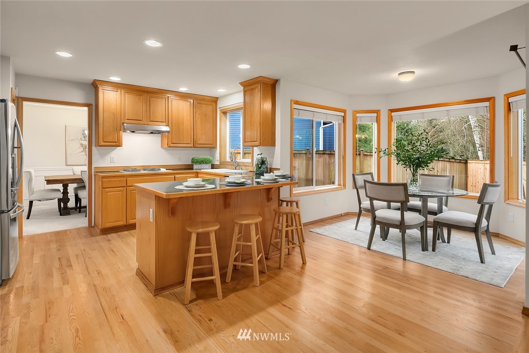 24204 18th Place West Bothell, WA 98021 - Photo 11 of 28 a dining hall with stainless steel appliances granite countertop a stove and a dining table with wooden floor