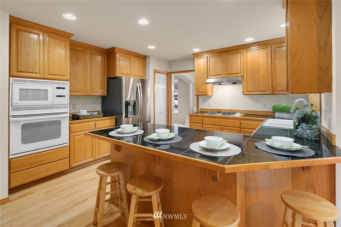 24204 18th Place West Bothell, WA 98021 - Photo 12 of 28 a kitchen with stainless steel appliances granite countertop a sink refrigerator and cabinets