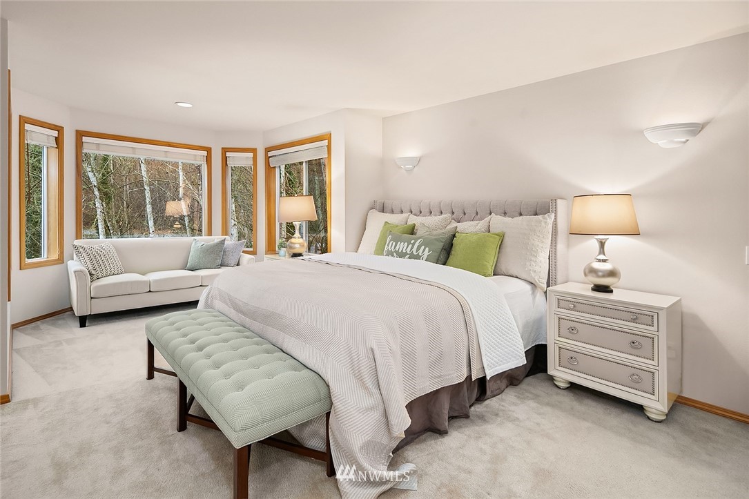 24204 18th Place West Bothell, WA 98021 - Photo 19 of 28 a spacious bedroom with a bed and a couch with large windows