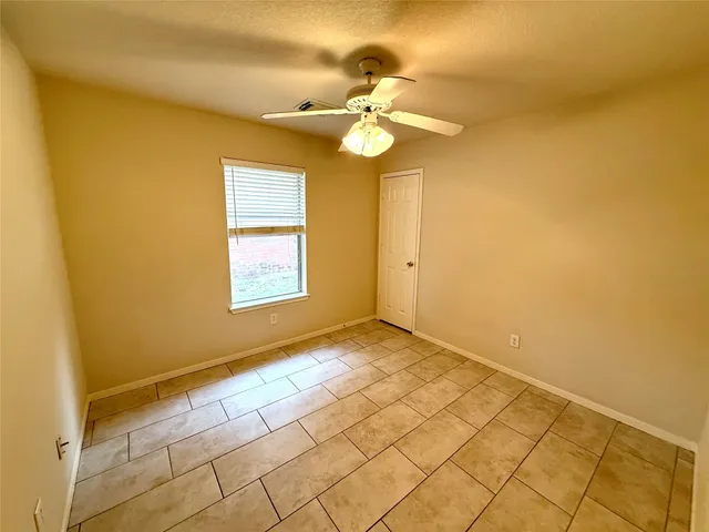 a view of a backyard with large trees and wooden fence