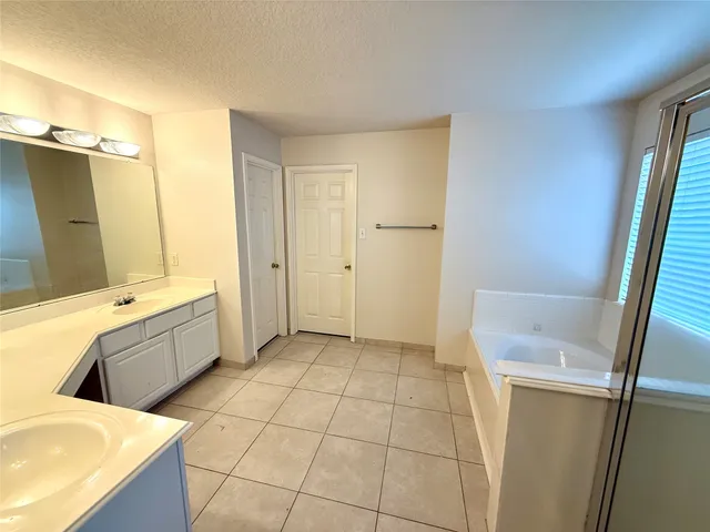 an empty room with wooden floor ceiling fan and windows