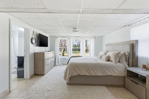 a bedroom with a large bed and a flat tv screen