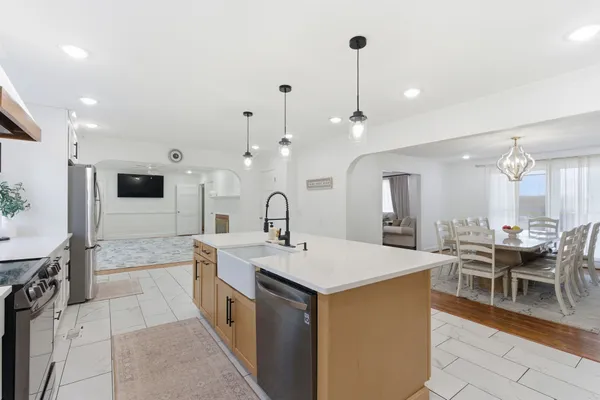 a large kitchen with kitchen island a sink a counter space and stainless steel appliances
