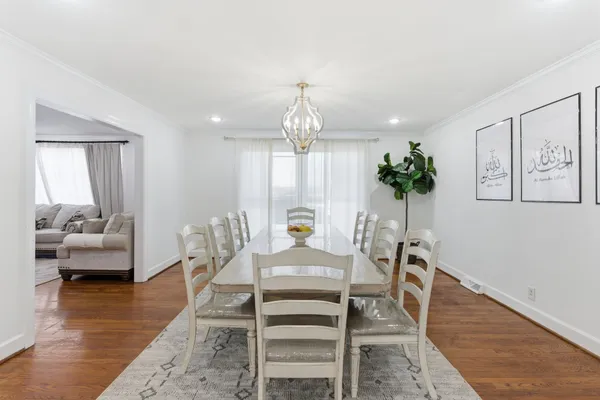 a dining room with furniture potted plants and wooden floor