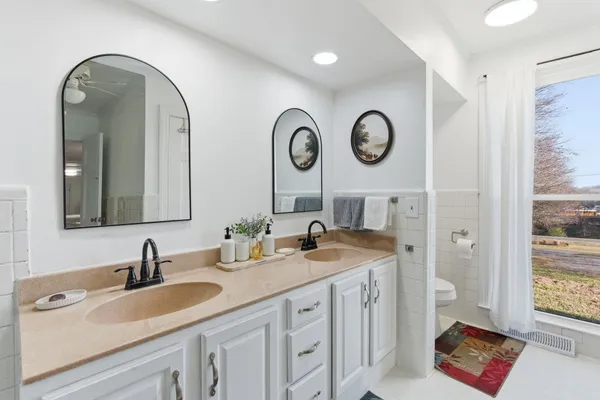 a bathroom with a granite countertop double vanity sink and a mirror