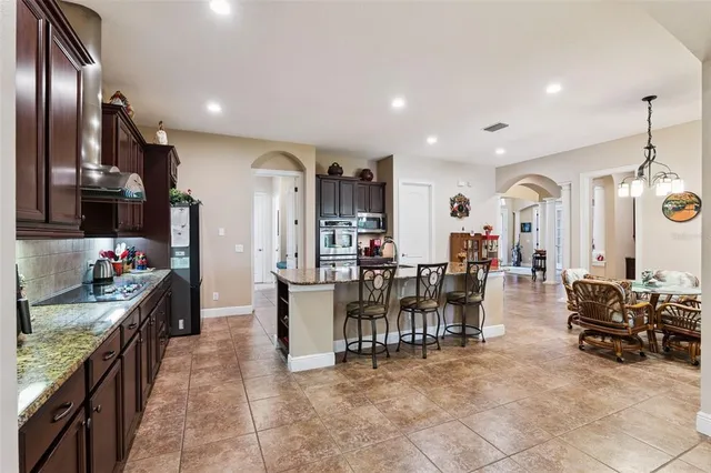 a kitchen with stainless steel appliances granite countertop wooden cabinets a refrigerator and a stove top oven