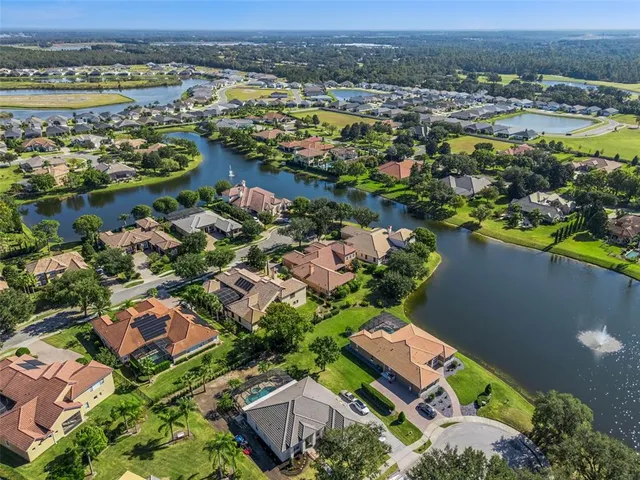 an aerial view of ocean and residential houses with outdoor space