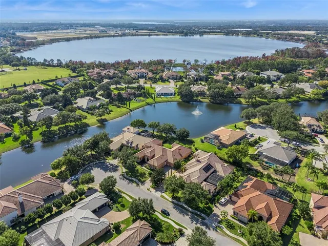 an aerial view of residential houses with outdoor space and lake view