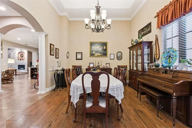 a very nice looking dining room with furniture a chandelier and wooden floor