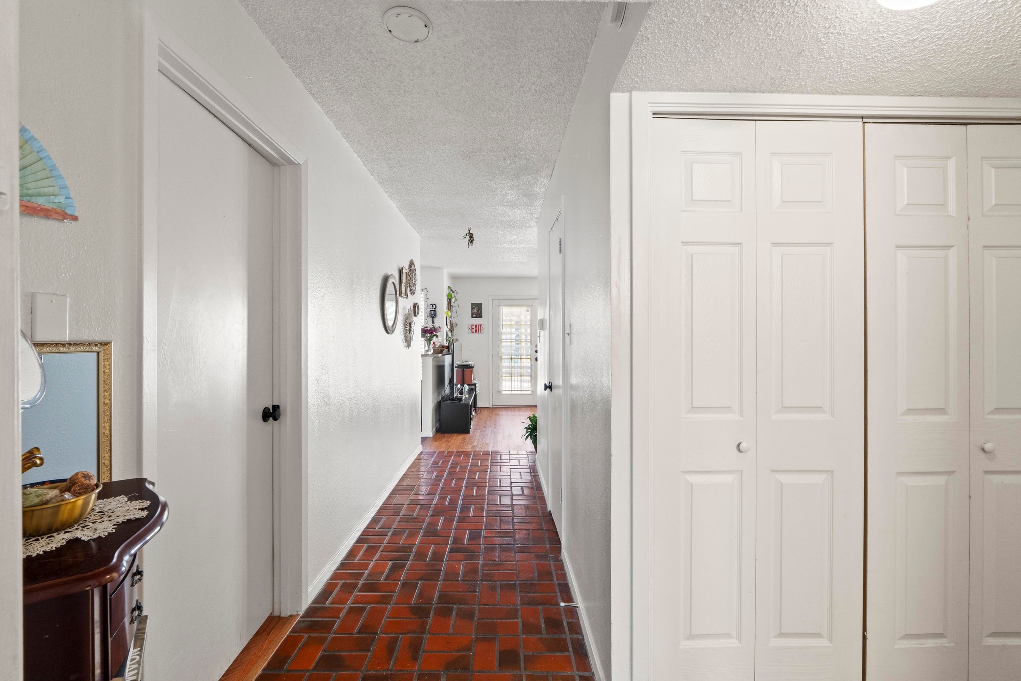 2110 Rio Grande Street, Unit 303 Austin, TX 78705 - Photo 21 of 22 Corridor featuring brick flooring and a textured ceiling