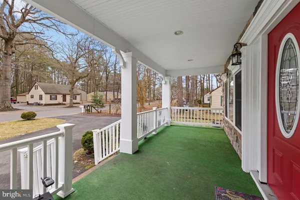 a living room with furniture kitchen view and a wooden floor