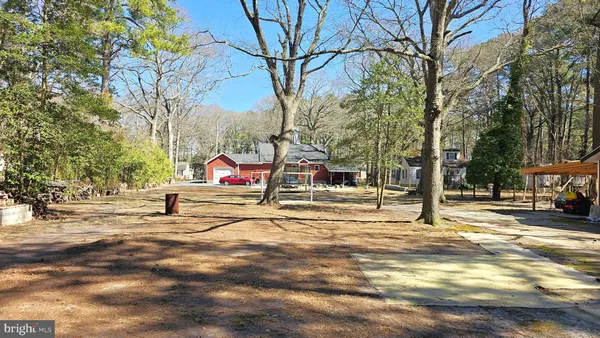 a front view of a house with a yard covered with snow and trees