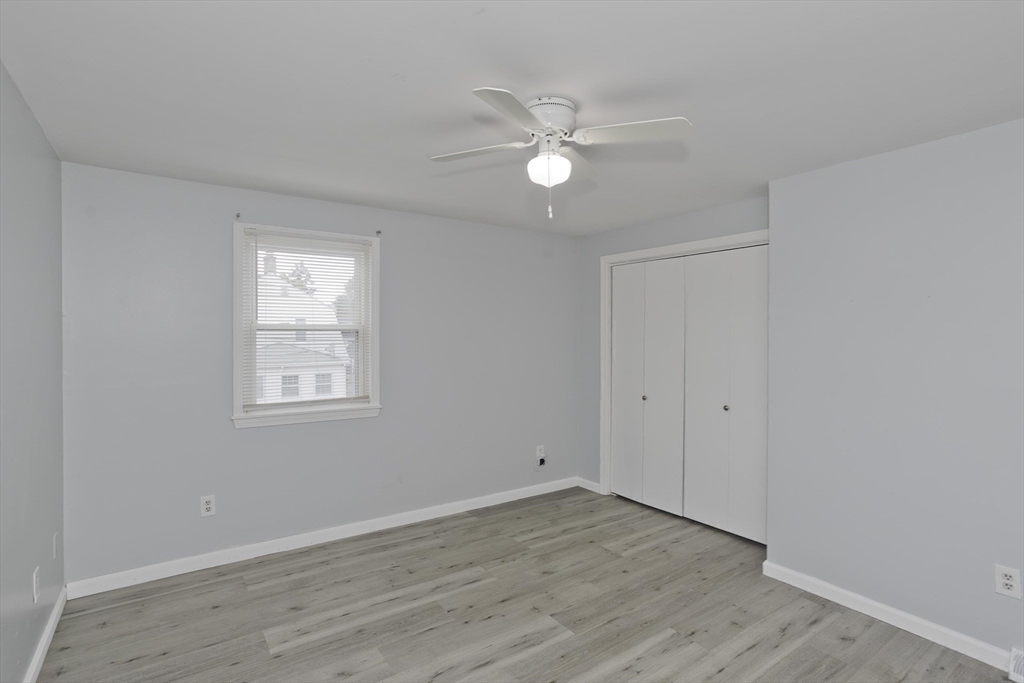 37-39 Porter Street Springfield, MA 01104 - Photo 14 of 40 an empty room with wooden floor fan and windows
