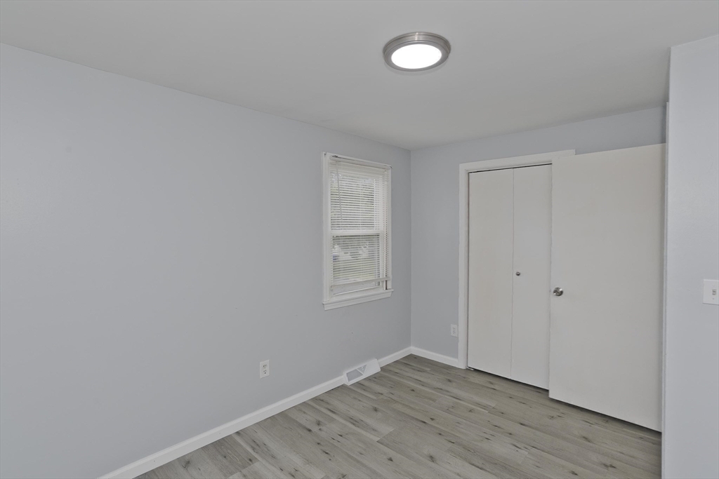 37-39 Porter Street Springfield, MA 01104 - Photo 21 of 40 a view of an empty room with wooden floor and a window