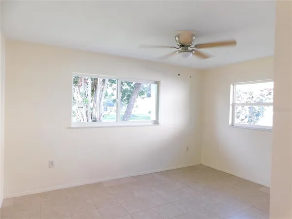 an empty room with a window and a fan
