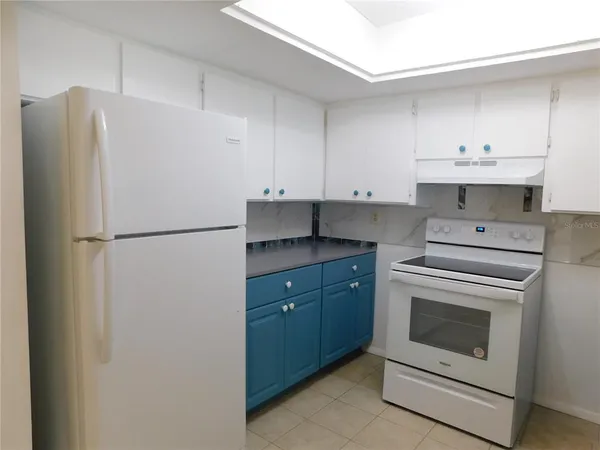 a kitchen with cabinets a refrigerator and a sink