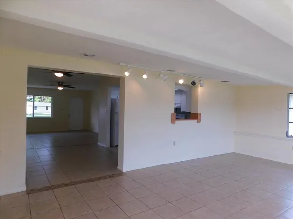 a view of a hallway with wooden floor and a kitchen