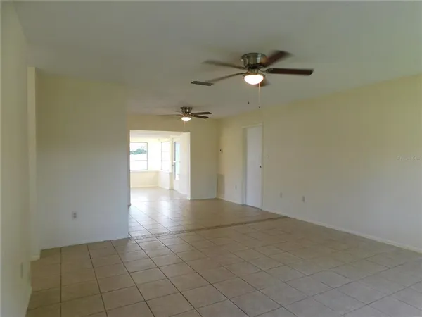 a view of an empty room and window chandelier fan