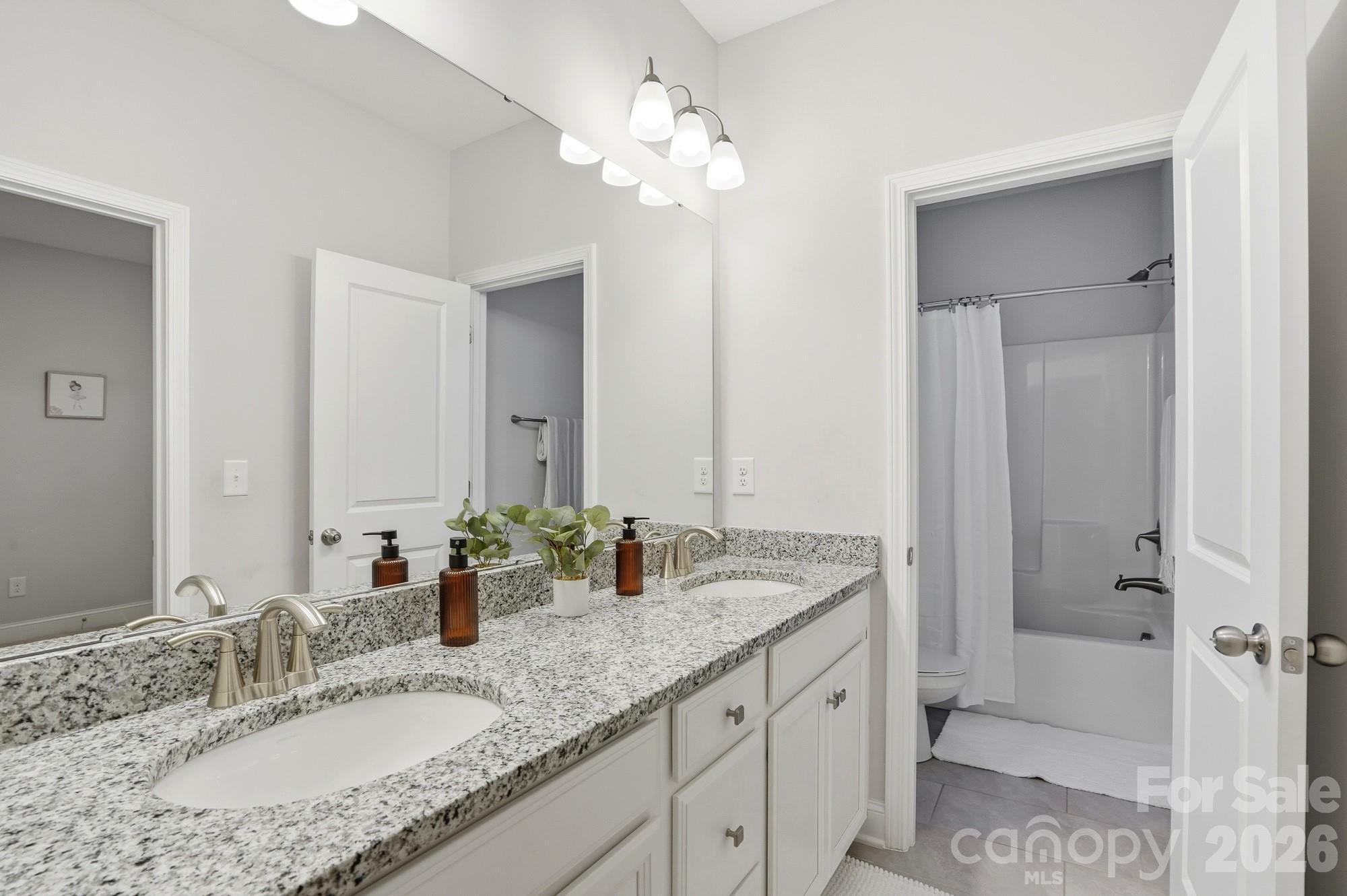 4044 Brandywine Terrace Lancaster, SC 29720 - Photo 40 of 48 a bathroom with a granite countertop double vanity sink large mirror and shower