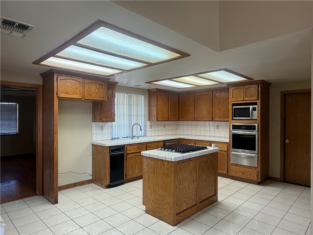 19609 Seneca Road Apple Valley, CA 92307 - Photo 10 of 37 a kitchen with a stove a sink and a refrigerator