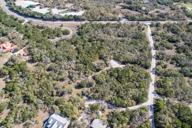 an aerial view of residential house with outdoor space and trees all around