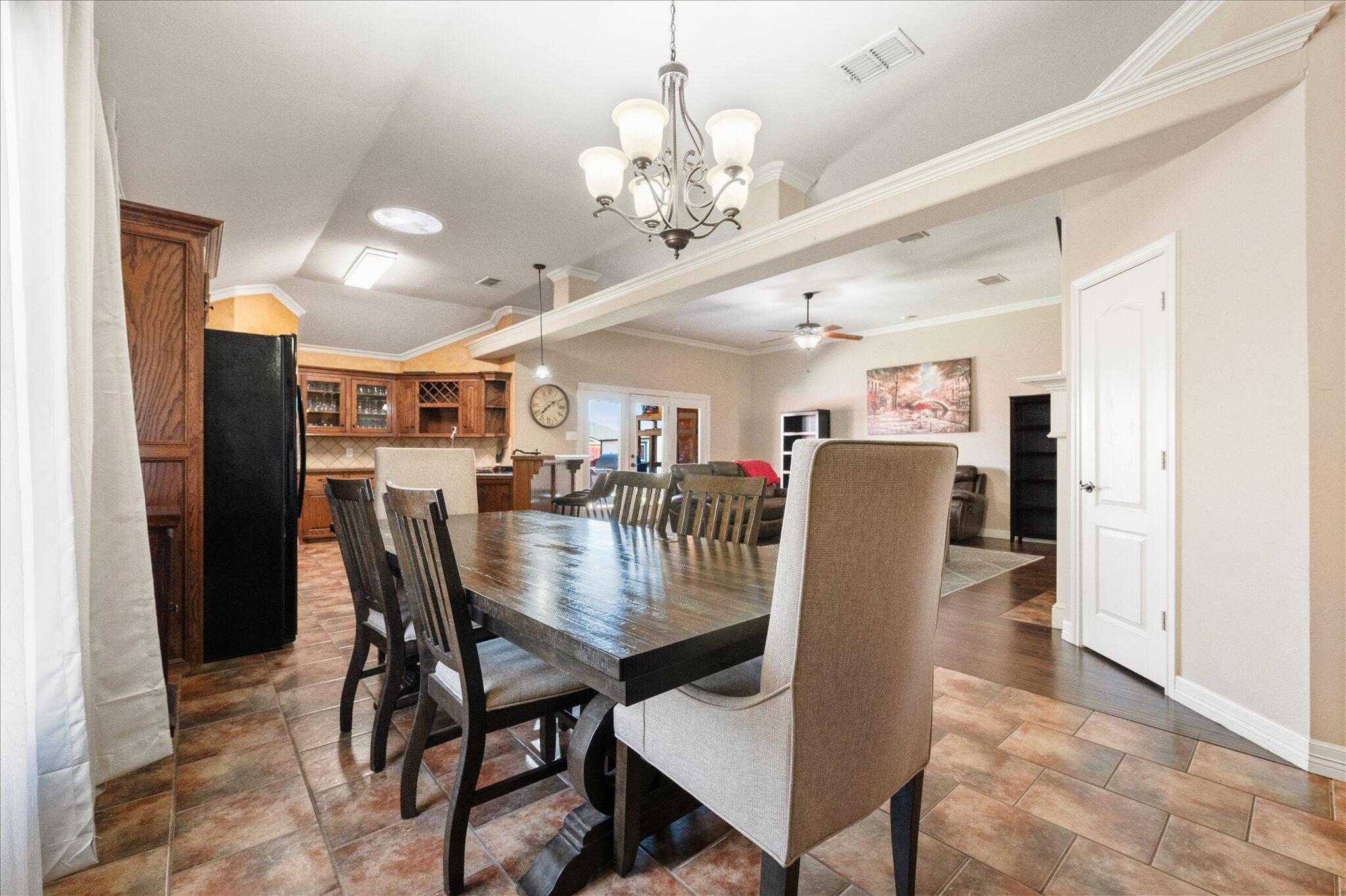 5704 107th Street Lubbock, TX 79424 - Photo 12 of 36 a view of a dining room with furniture and a chandelier