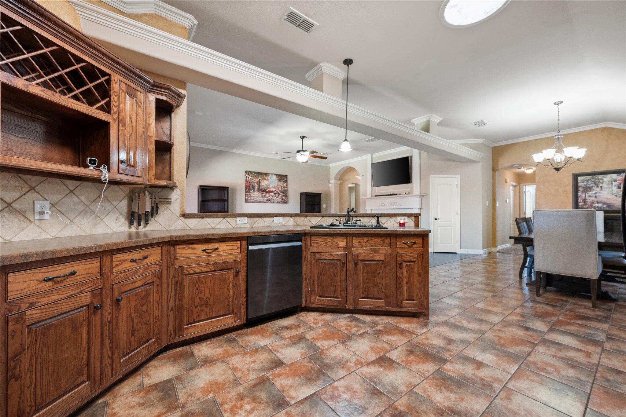 5704 107th Street Lubbock, TX 79424 - Photo 13 of 36 a large kitchen with stainless steel appliances granite countertop a sink and cabinets