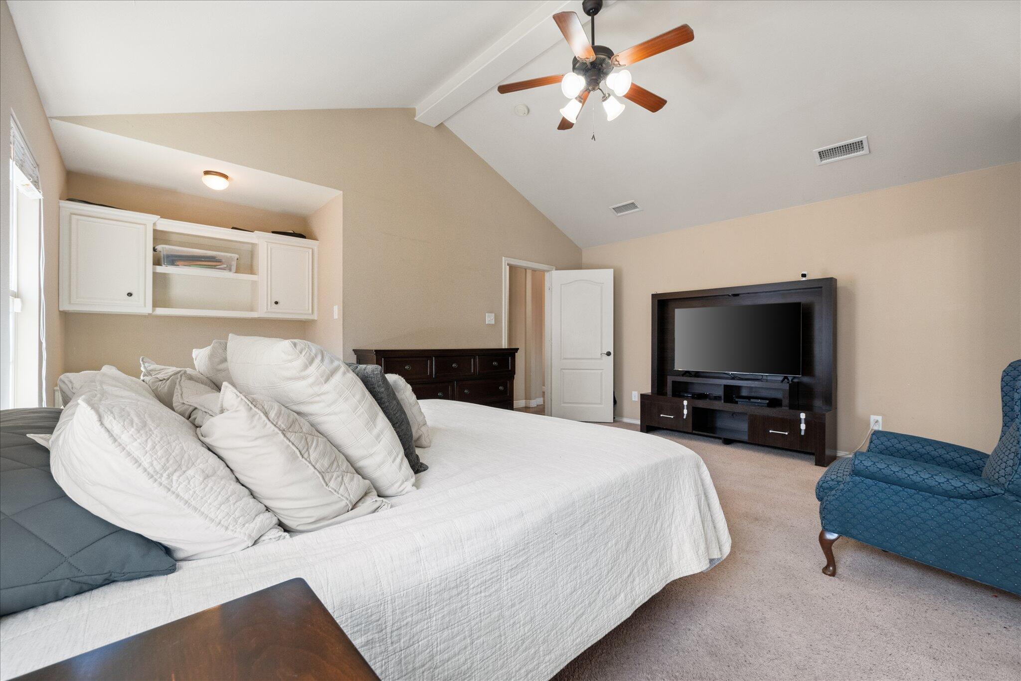 5704 107th Street Lubbock, TX 79424 - Photo 20 of 36 a bedroom with bed and a flat screen tv