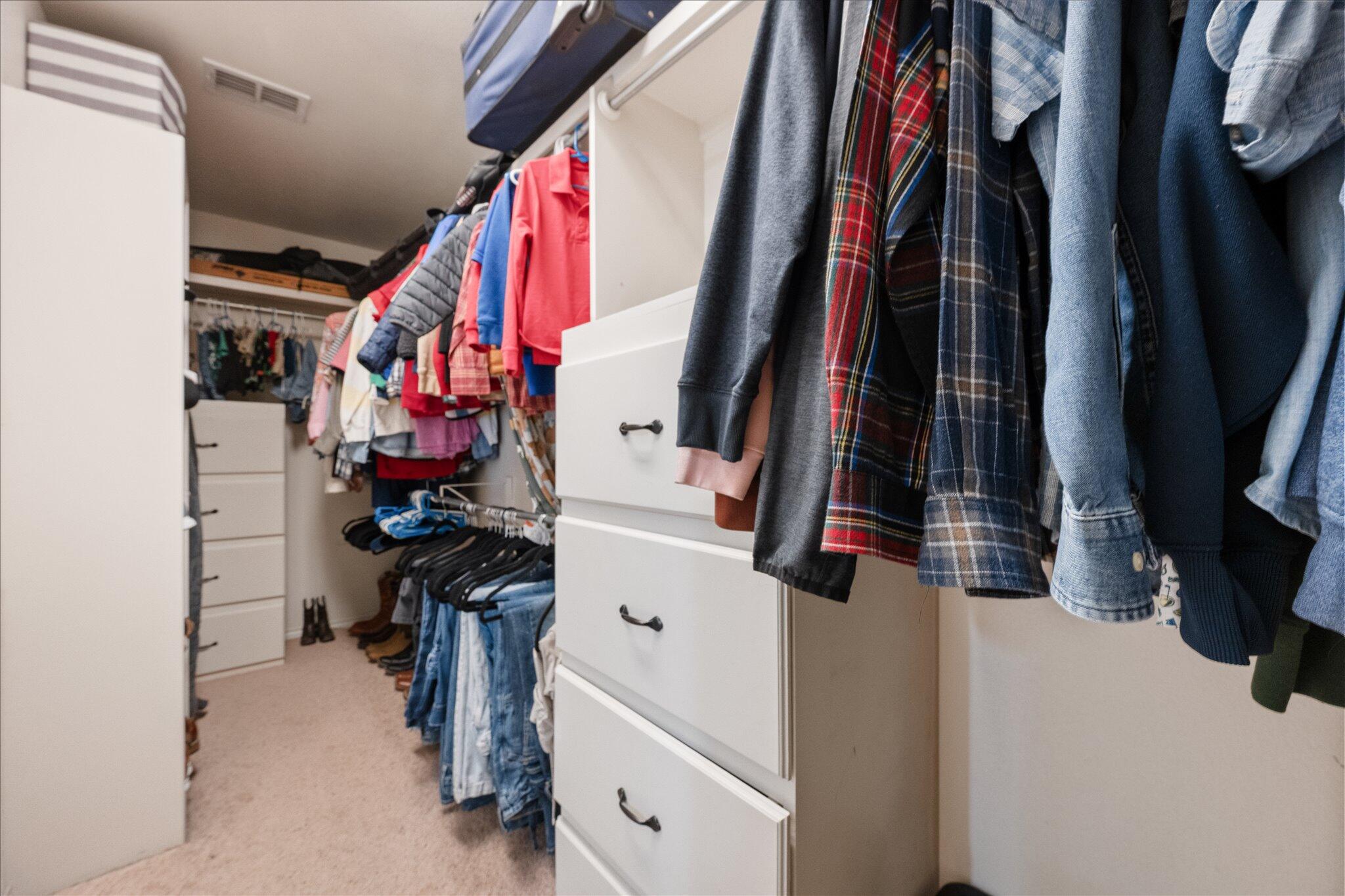 5704 107th Street Lubbock, TX 79424 - Photo 27 of 36 a view of walk in closet with clothes and shoes