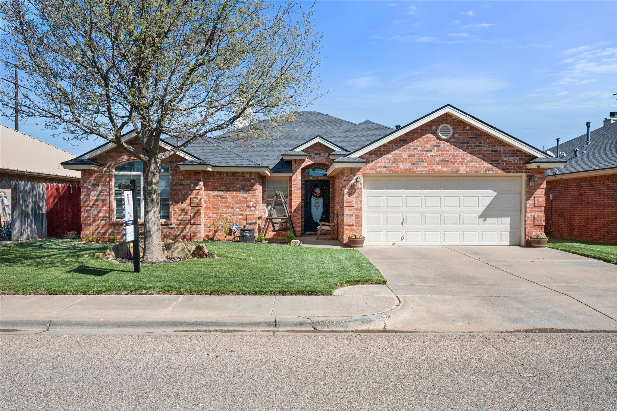 5704 107th Street Lubbock, TX 79424 - Photo 3 of 36 a front view of a house with a yard and garage