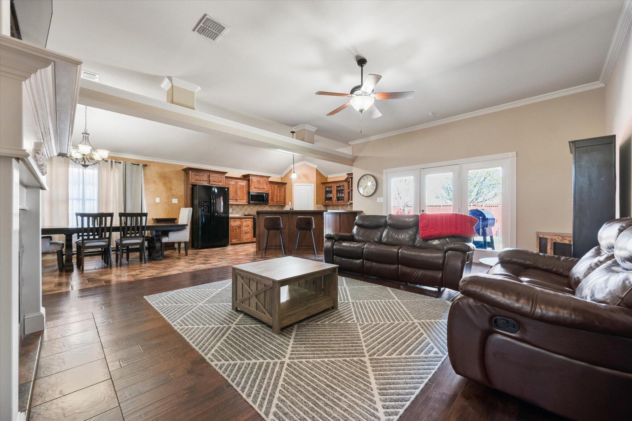 5704 107th Street Lubbock, TX 79424 - Photo 7 of 36 a living room with furniture and a chandelier