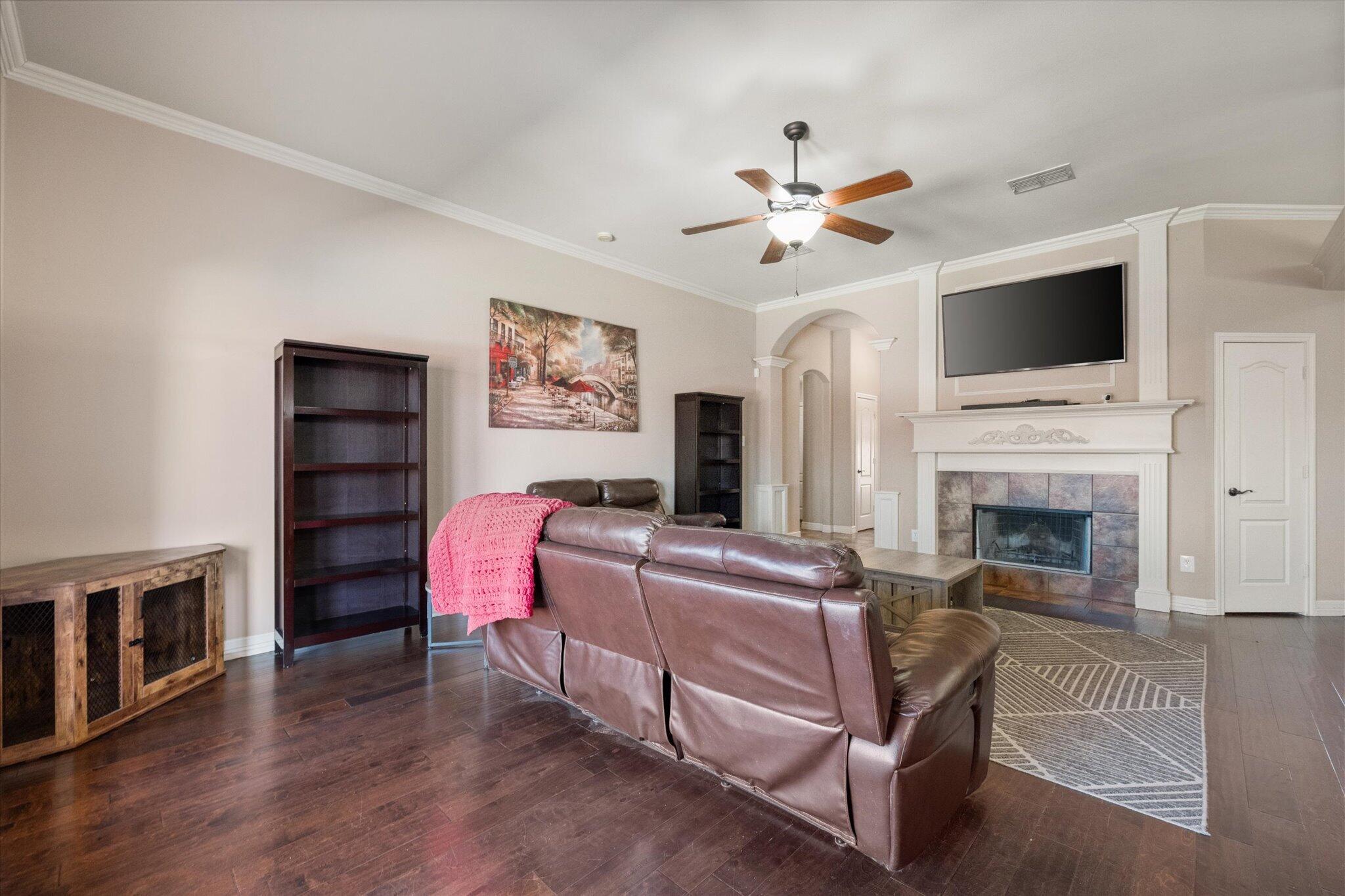 5704 107th Street Lubbock, TX 79424 - Photo 9 of 36 a living room with furniture a flat screen tv and a fireplace