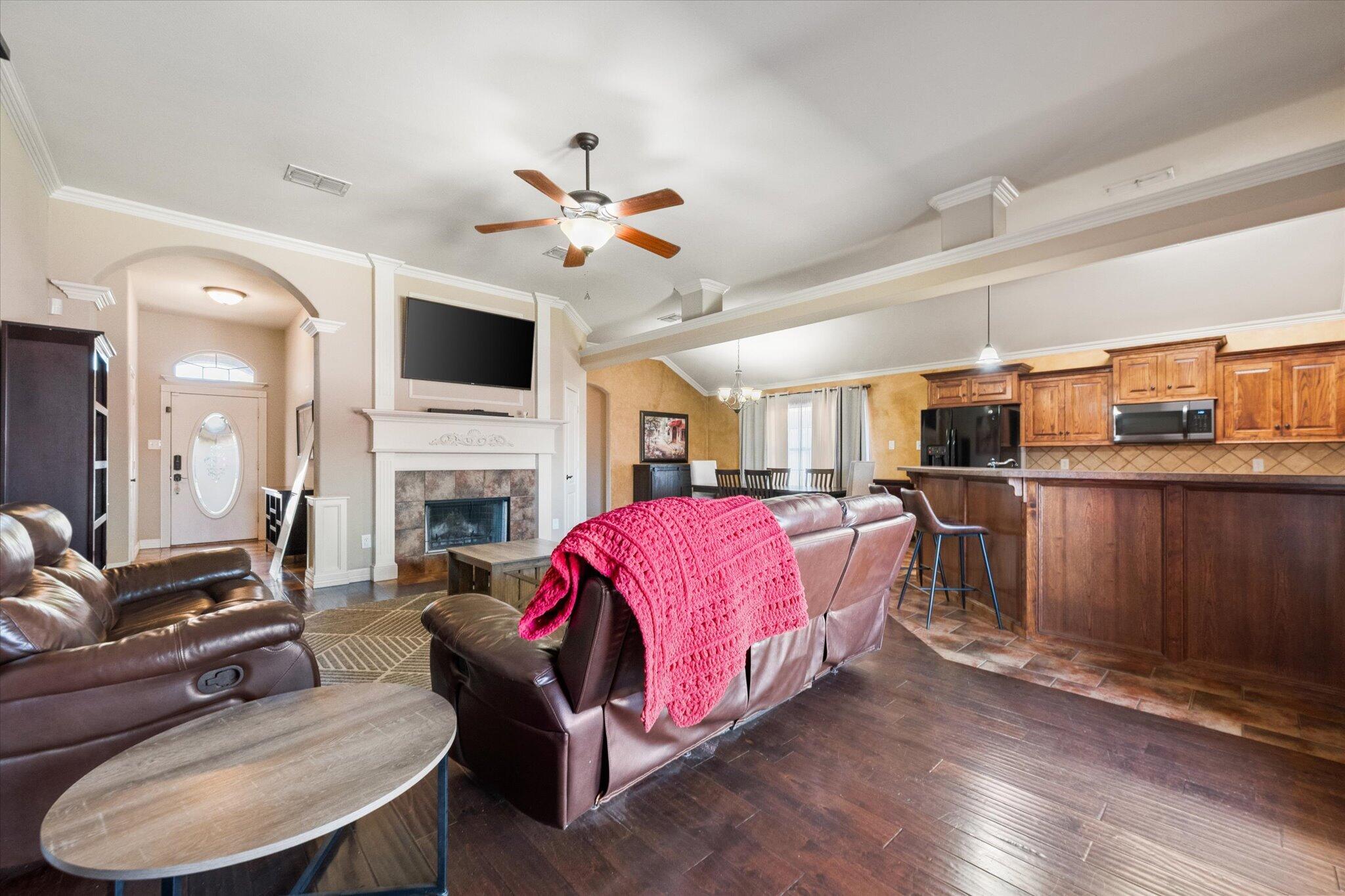 5704 107th Street Lubbock, TX 79424 - Photo 10 of 36 a living room with furniture a fireplace and a flat screen tv