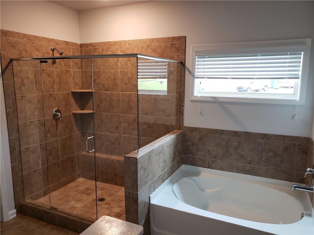 4735 Watkins Way Cumming, GA 30040 - Photo 17 of 31 a bathroom with a bathtub and a shower
