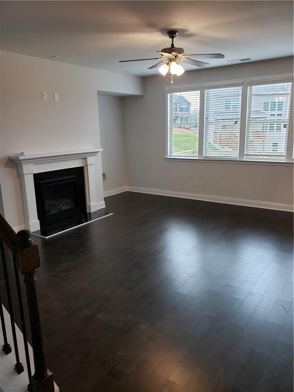 4735 Watkins Way Cumming, GA 30040 - Photo 5 of 31 an empty room with windows fireplace and wooden floor