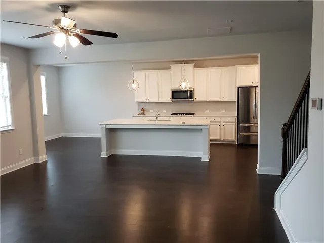 a view of kitchen with wooden floor electronic appliances and window