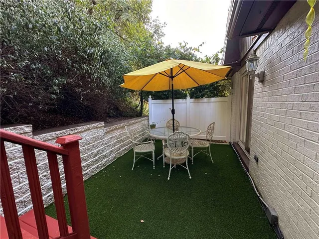 a backyard of a house with wooden floor and fence