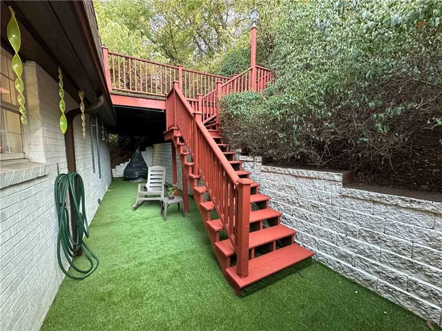 a view of staircase with lots of frames on wall and a large window