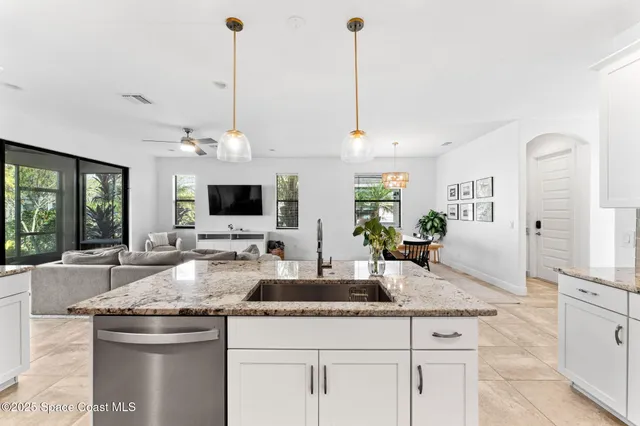 a kitchen with stainless steel appliances granite countertop a sink a stove and a wooden floors