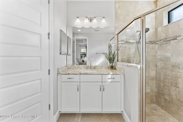 a bathroom with a granite countertop sink a mirror and a shower